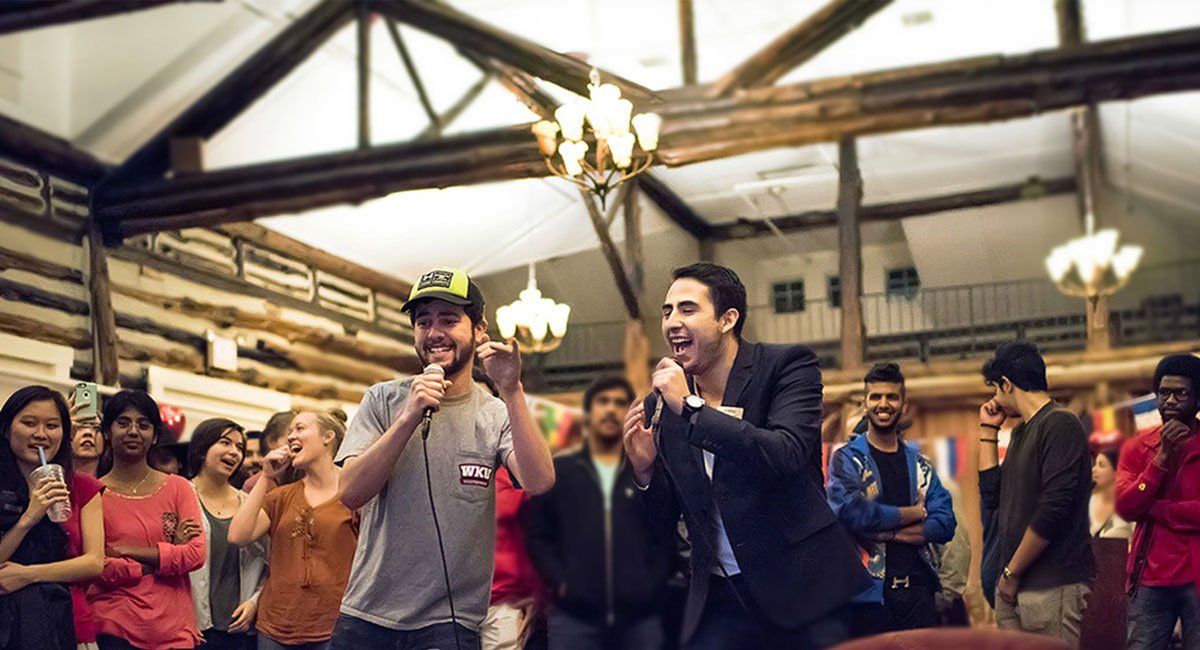 Two students singing karaoke at an event