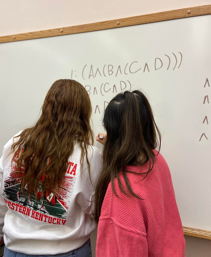 Two student working on a symbolic logic problem.