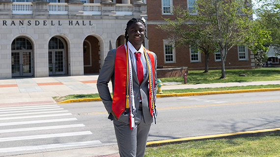 Ikechukwu Micheal Diugu, a psychology graduate, smiles confidently while standing outdoors...