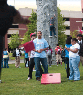 Students climbing and playing cornhole