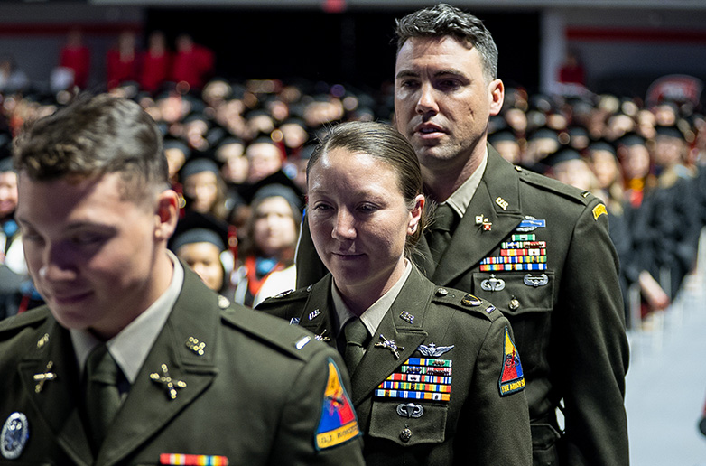 Male and female military veterans in Army dress uniforms walking in the WKU commencement ceremony