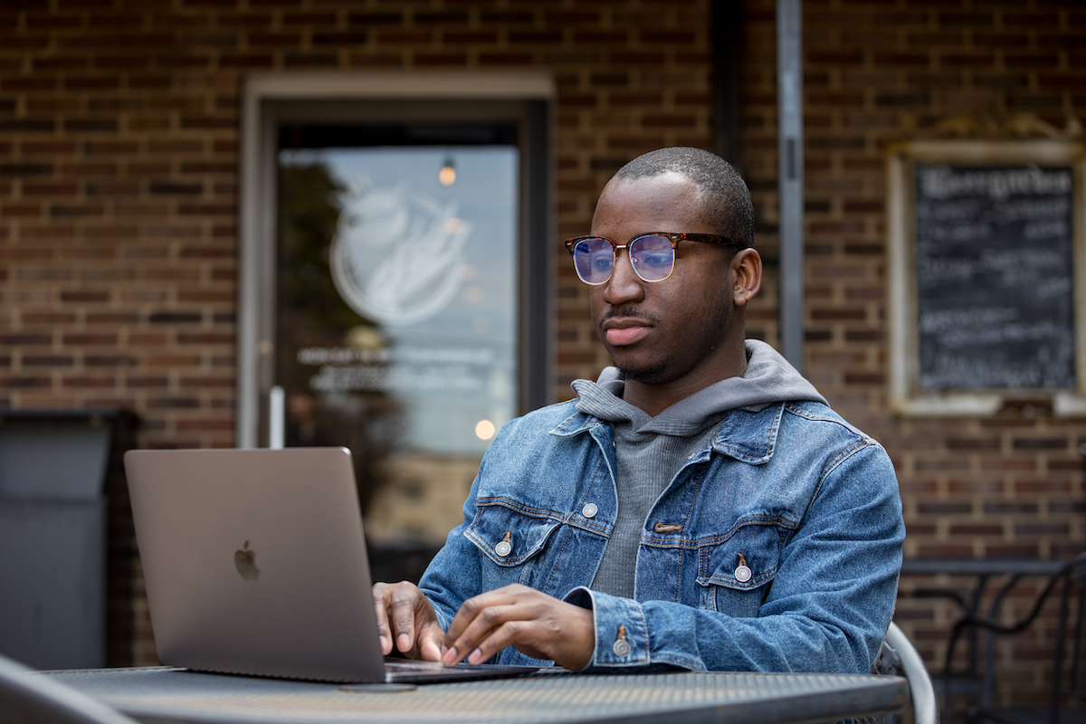 A WKU Online student works on his laptop off-campus.
