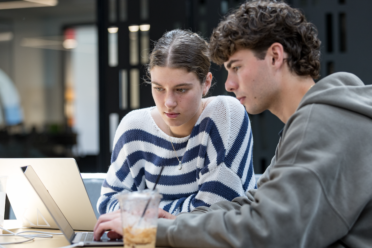 Two WKU students look at a laptop.