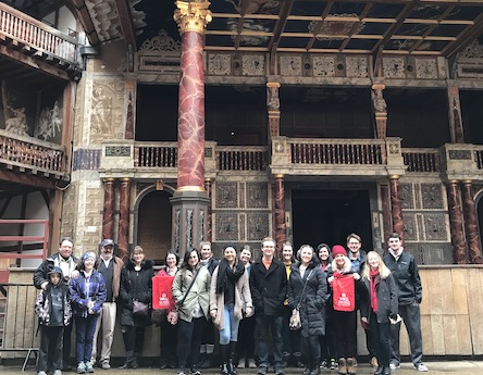 A large group of students on the Harlaxton study abroad trip posing inside the Globe Theatre in London