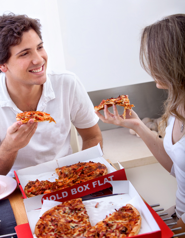 Two people eating pizza